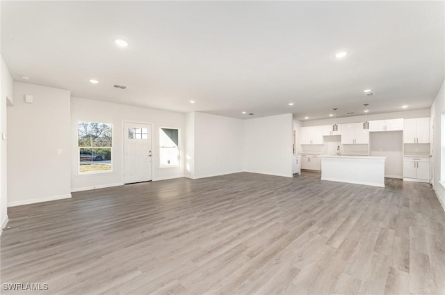 unfurnished living room with light wood-type flooring