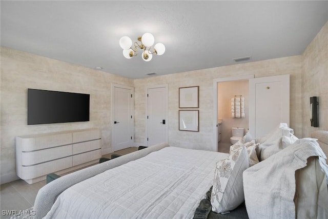 bedroom featuring connected bathroom and an inviting chandelier