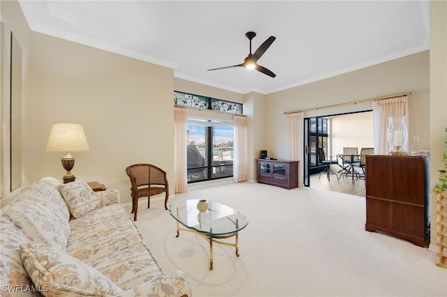 carpeted living room featuring ceiling fan and crown molding