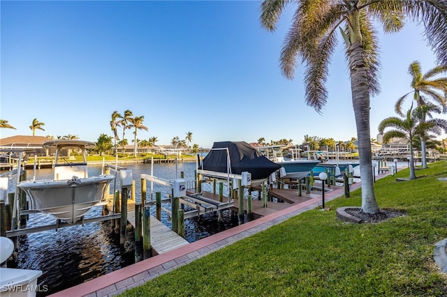 view of dock with a lawn and a water view