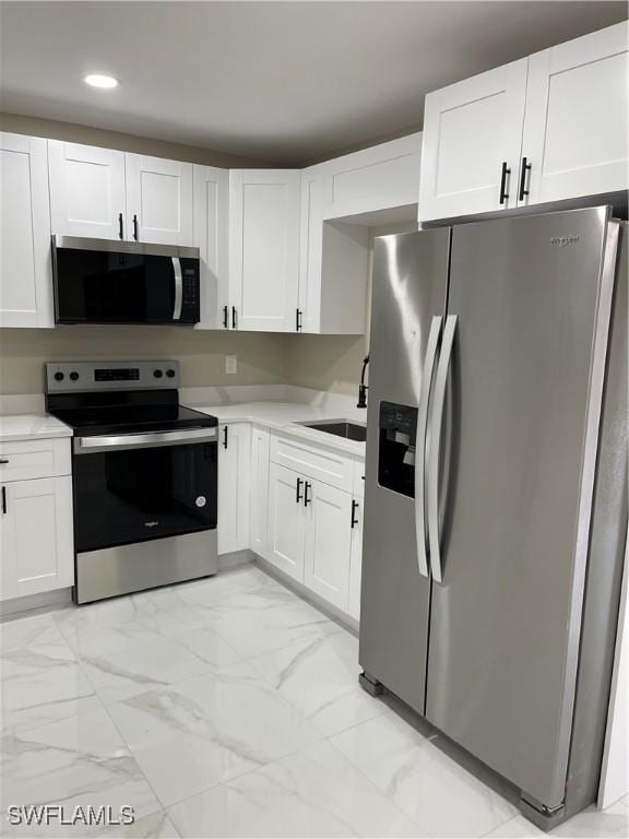 kitchen with stainless steel appliances, sink, and white cabinets