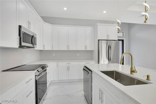 kitchen featuring light stone countertops, stainless steel appliances, sink, white cabinets, and hanging light fixtures