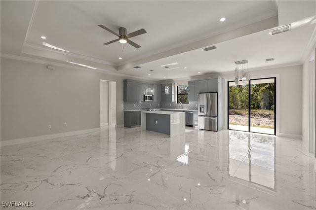 kitchen with gray cabinetry, ornamental molding, decorative light fixtures, a kitchen island, and stainless steel appliances