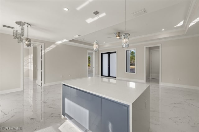 kitchen with a raised ceiling, hanging light fixtures, and crown molding