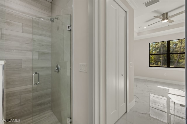 bathroom featuring ceiling fan, a shower with door, and ornamental molding