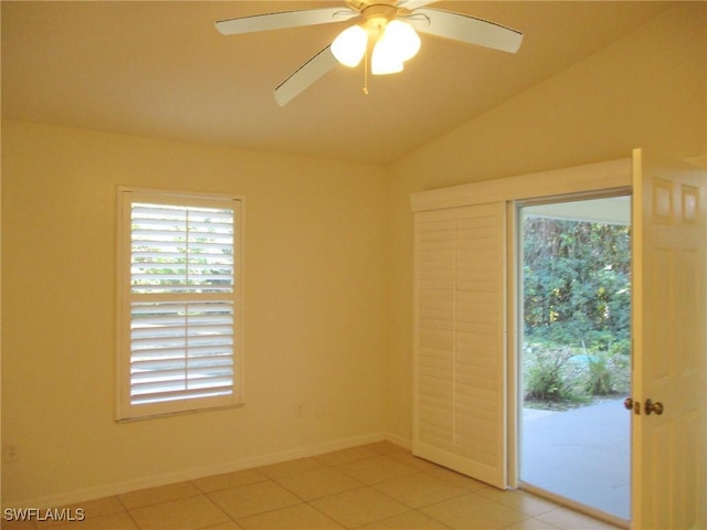 empty room featuring ceiling fan, lofted ceiling, and light tile patterned floors