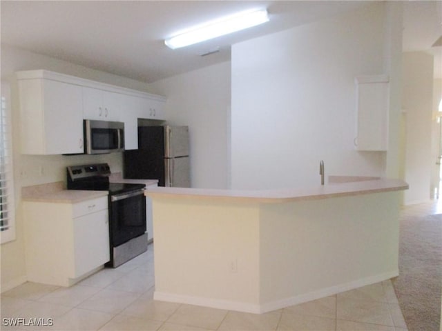 kitchen featuring white cabinets, light tile patterned floors, stainless steel appliances, and kitchen peninsula