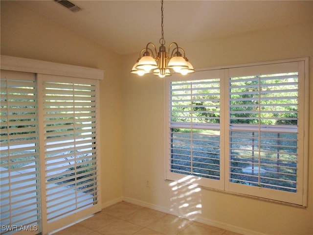 unfurnished room featuring a notable chandelier, light tile patterned flooring, and vaulted ceiling