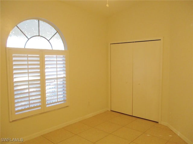 unfurnished bedroom with a closet and light tile patterned flooring