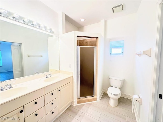 bathroom featuring toilet, vanity, and walk in shower