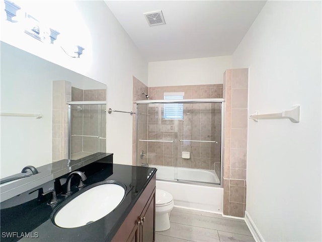 full bathroom featuring vanity, enclosed tub / shower combo, and toilet