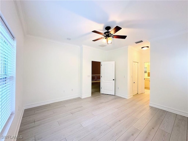 spare room with ceiling fan, ornamental molding, and light wood-type flooring