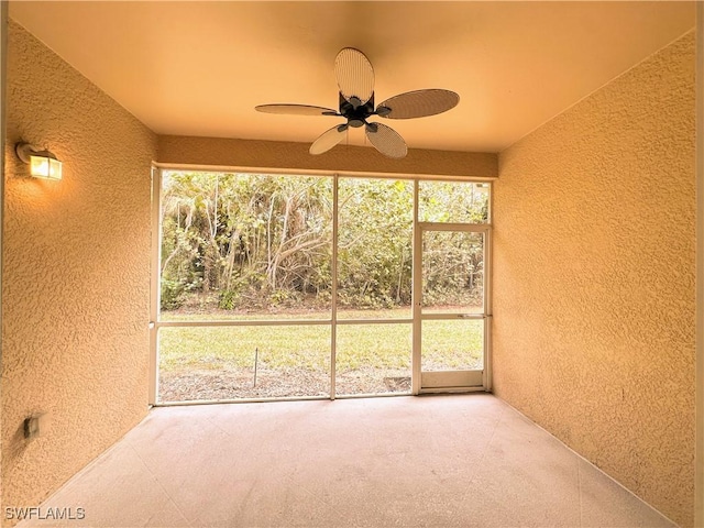 unfurnished sunroom with ceiling fan and plenty of natural light