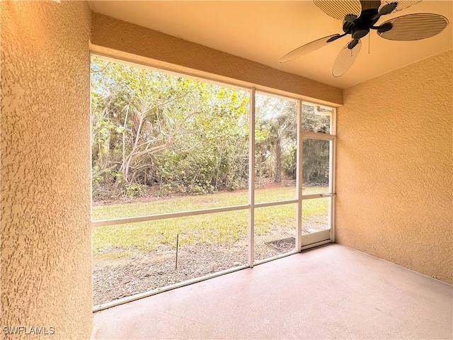 unfurnished sunroom featuring plenty of natural light and ceiling fan