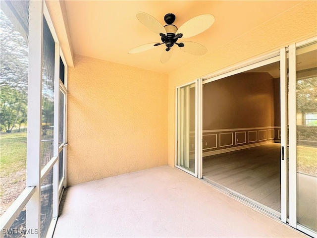 unfurnished sunroom featuring ceiling fan and plenty of natural light