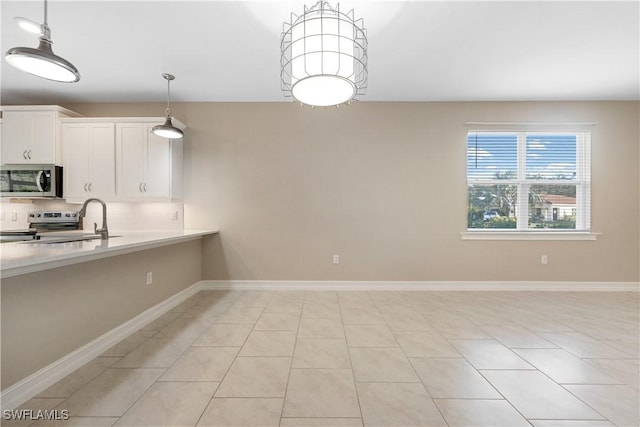 kitchen with decorative light fixtures, decorative backsplash, sink, appliances with stainless steel finishes, and white cabinets