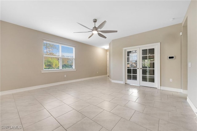 empty room with ceiling fan, light tile patterned floors, and french doors