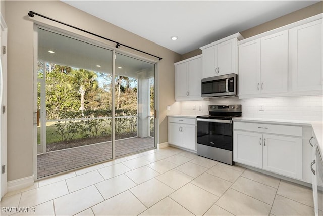 kitchen featuring tasteful backsplash, light tile patterned floors, appliances with stainless steel finishes, and white cabinetry