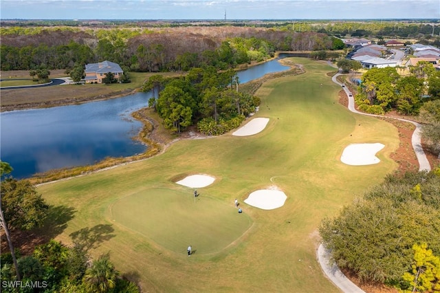 drone / aerial view featuring view of golf course, a forest view, and a water view