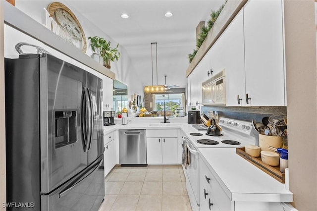 kitchen with decorative light fixtures, light tile patterned floors, white cabinetry, and appliances with stainless steel finishes