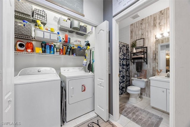 washroom with washing machine and clothes dryer, sink, and light tile patterned flooring