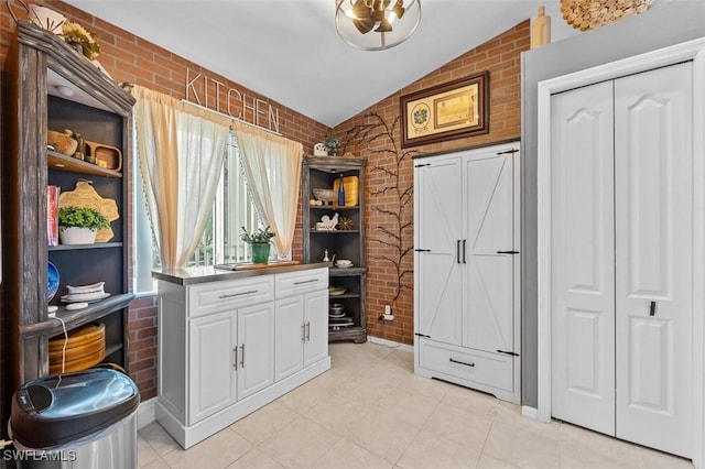 interior space featuring light tile patterned floors and vaulted ceiling