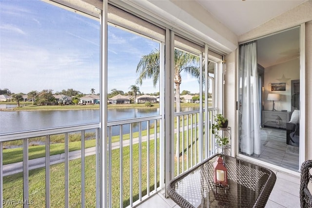 unfurnished sunroom with a water view and vaulted ceiling