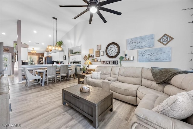 living room featuring ceiling fan, lofted ceiling, and light hardwood / wood-style flooring