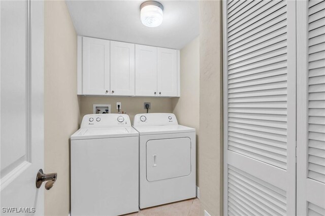 laundry area with washer and dryer, cabinet space, and light tile patterned floors