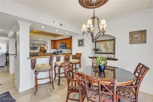 dining room with baseboards, an inviting chandelier, visible vents, and crown molding