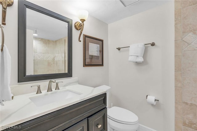 bathroom featuring toilet, baseboards, and vanity