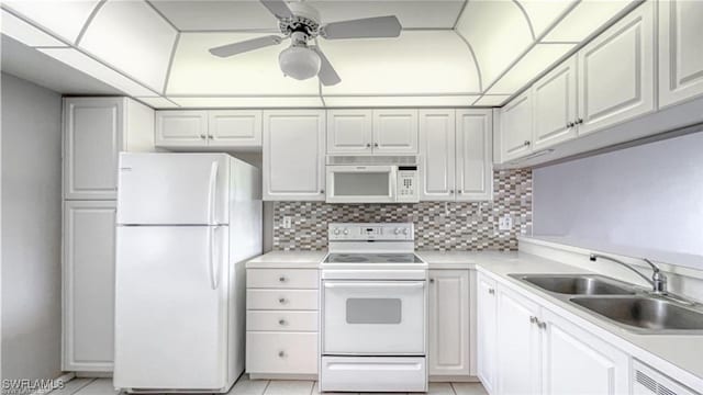 kitchen featuring decorative backsplash, white appliances, sink, white cabinets, and light tile patterned flooring