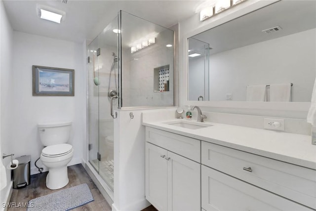 bathroom with hardwood / wood-style flooring, vanity, toilet, and an enclosed shower