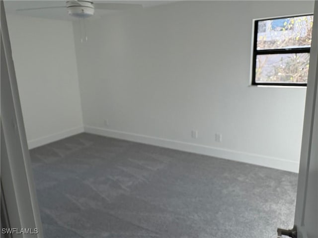 carpeted spare room featuring ceiling fan