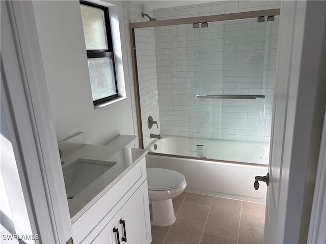 full bathroom featuring tile patterned floors, vanity, bath / shower combo with glass door, and toilet