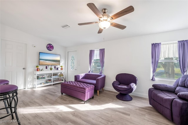 living room with ceiling fan, a healthy amount of sunlight, vaulted ceiling, and light hardwood / wood-style floors