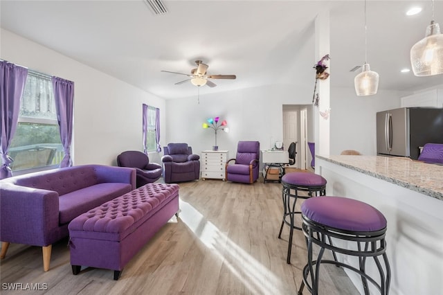 living room featuring ceiling fan and light hardwood / wood-style flooring