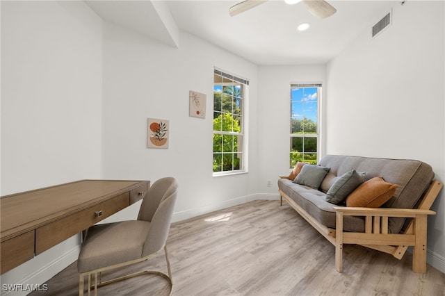 office with light hardwood / wood-style floors and ceiling fan