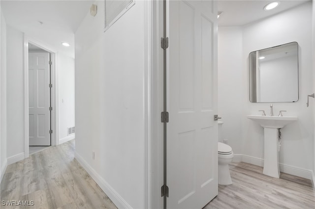 bathroom featuring hardwood / wood-style floors and toilet