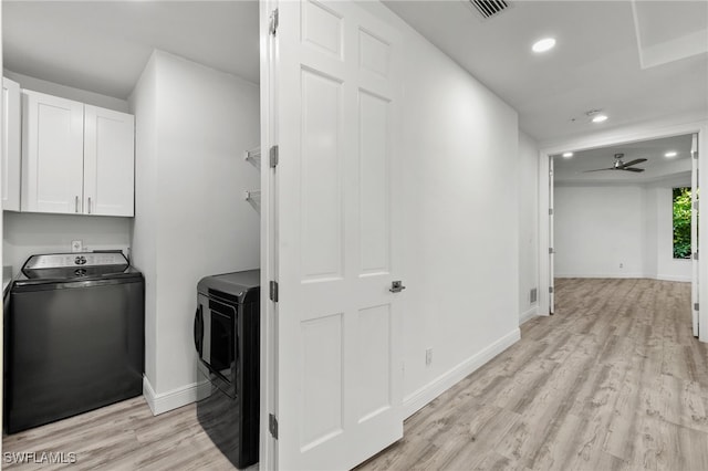 clothes washing area with cabinets, ceiling fan, washing machine and dryer, and light hardwood / wood-style flooring