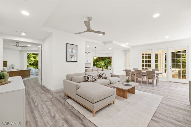 living room featuring ceiling fan and light hardwood / wood-style flooring