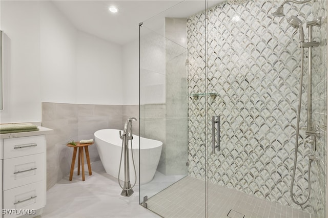 bathroom featuring shower with separate bathtub and tile walls