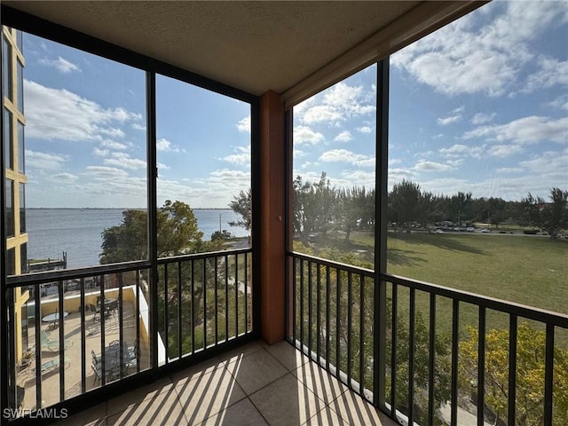 sunroom featuring a water view