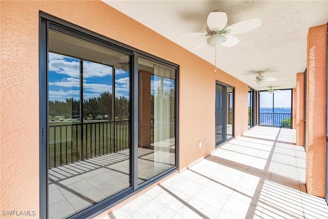 exterior space featuring ceiling fan and a water view