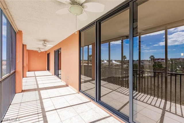 unfurnished sunroom with ceiling fan