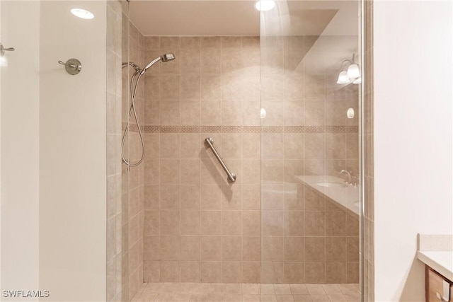 bathroom featuring a tile shower and vanity