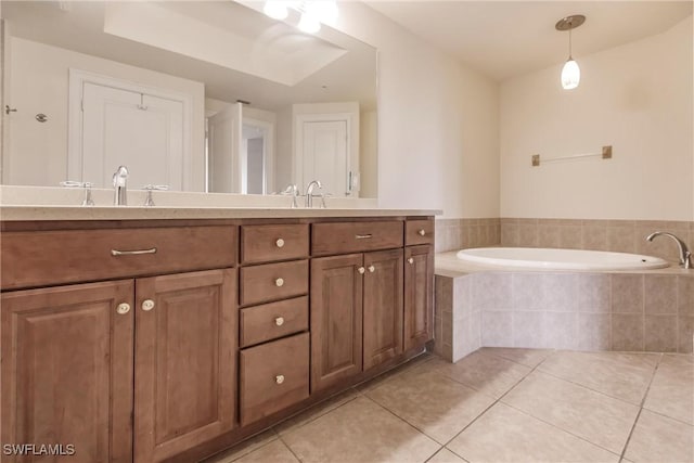 bathroom with tile patterned flooring, vanity, and tiled tub