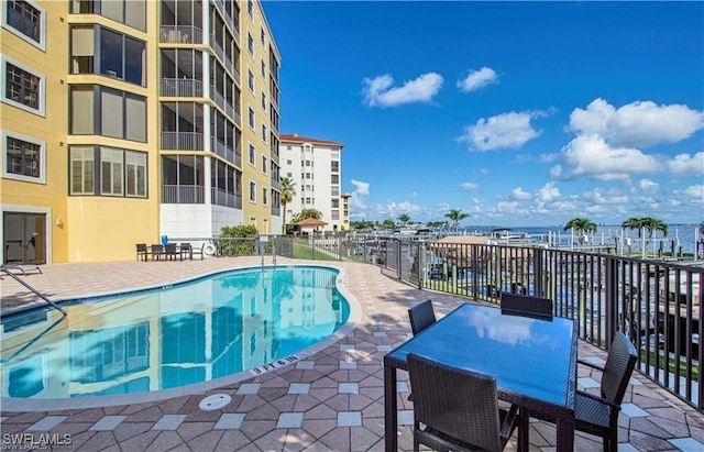 view of pool with a patio area and a water view