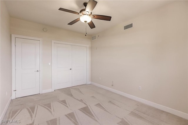 unfurnished bedroom featuring ceiling fan, light carpet, and a closet