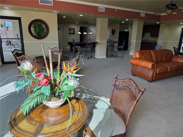 carpeted living room featuring crown molding and ceiling fan